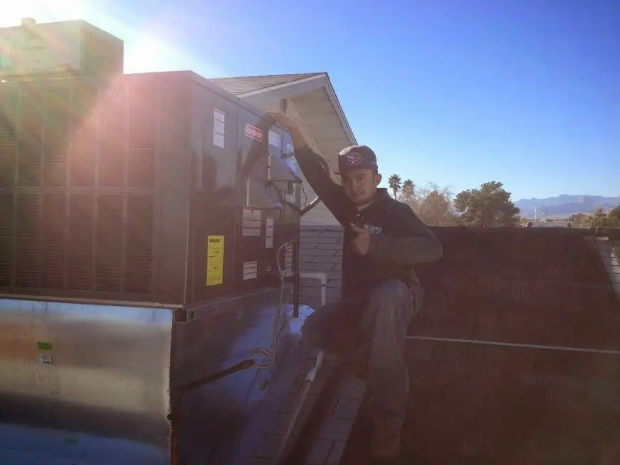 HVAC technician performing AC Tune-Up on a rooftop unit in Central Point